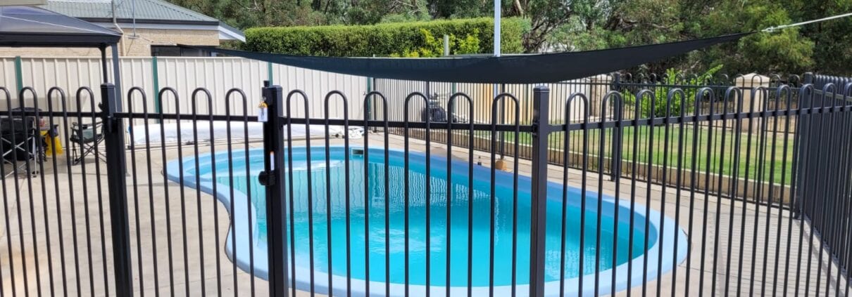 photo of a swimming pool and metal fence