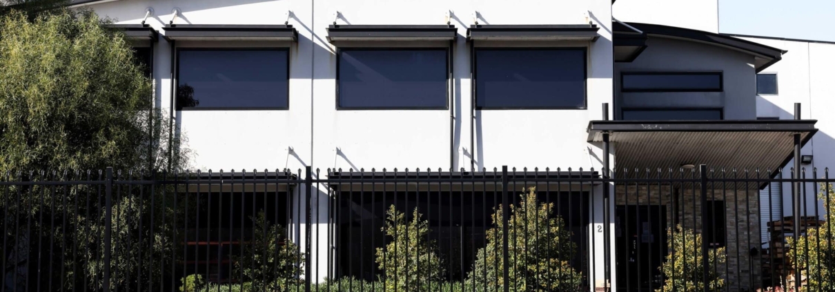 A photo of a commercial building with garrison fencing at the front.