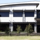 A photo of a commercial building with garrison fencing at the front.