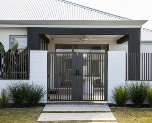 A photo of a house with batten fencing and a matching gate.